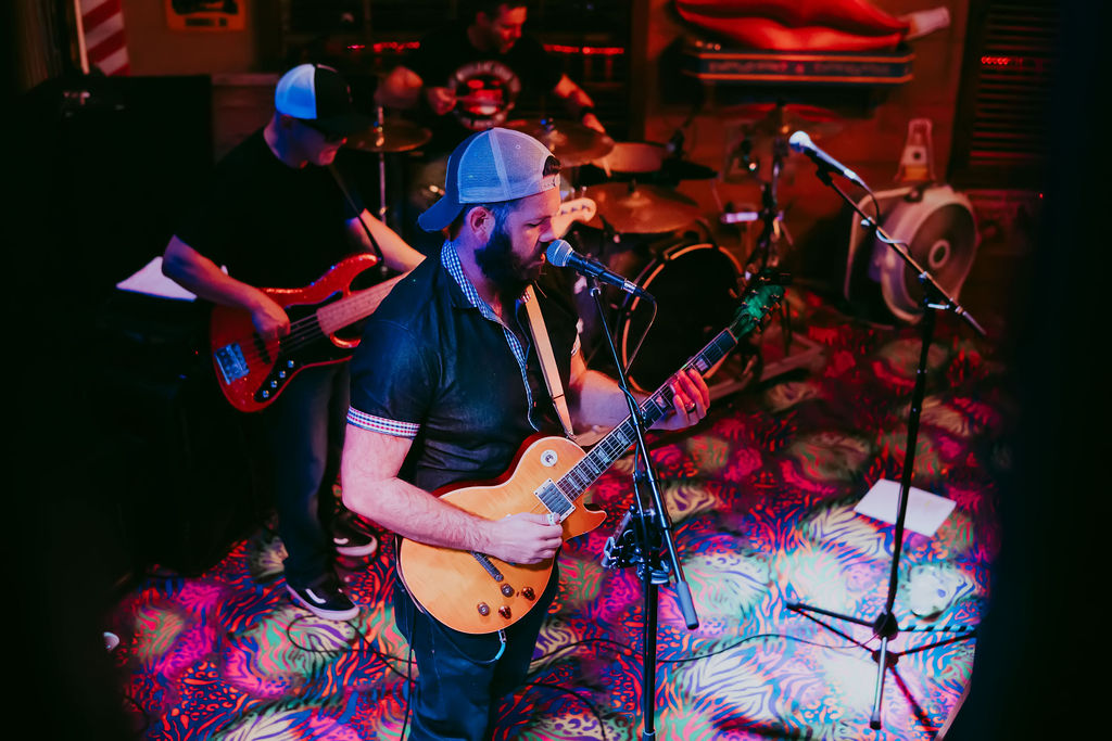 Jon Jimmerson singing and playing guitar with a live band